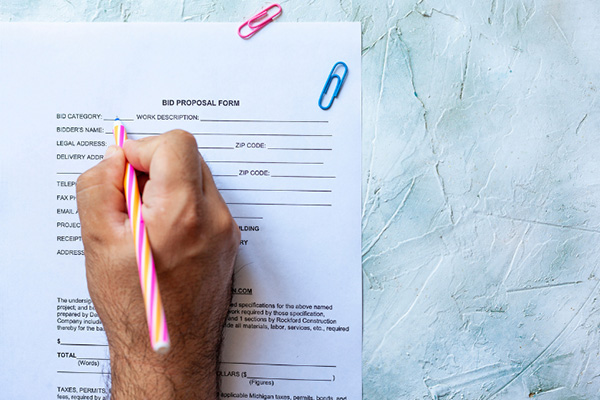 Close up of a hand holding a pen and filling out an application.