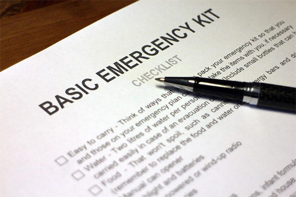 A paper titled Basic Emergency Kit, and a pen