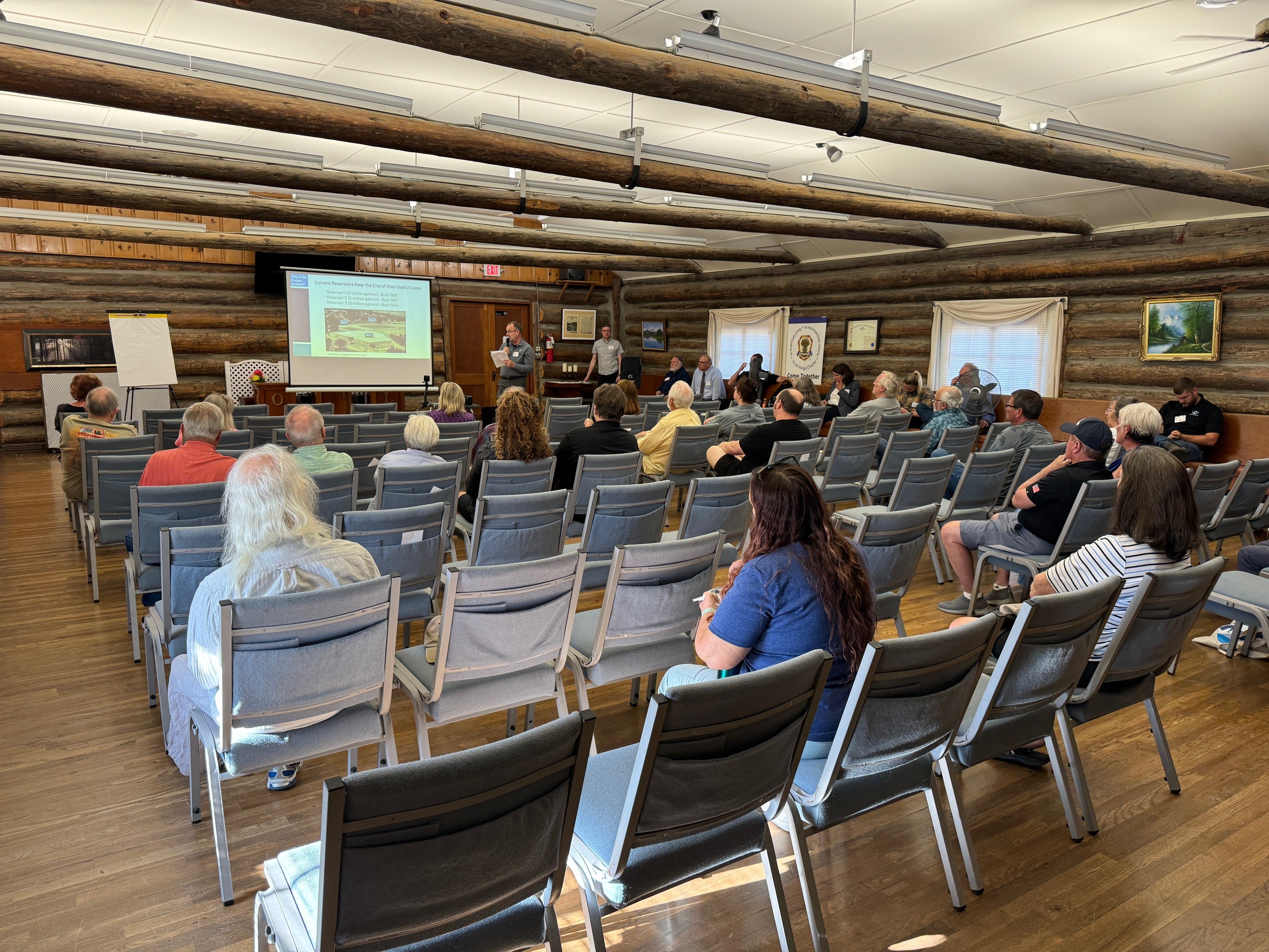 Group in log cabin view presentation about Capitol Hill reservoir replacement project