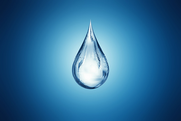 A singular water droplet against a blue vignetted background